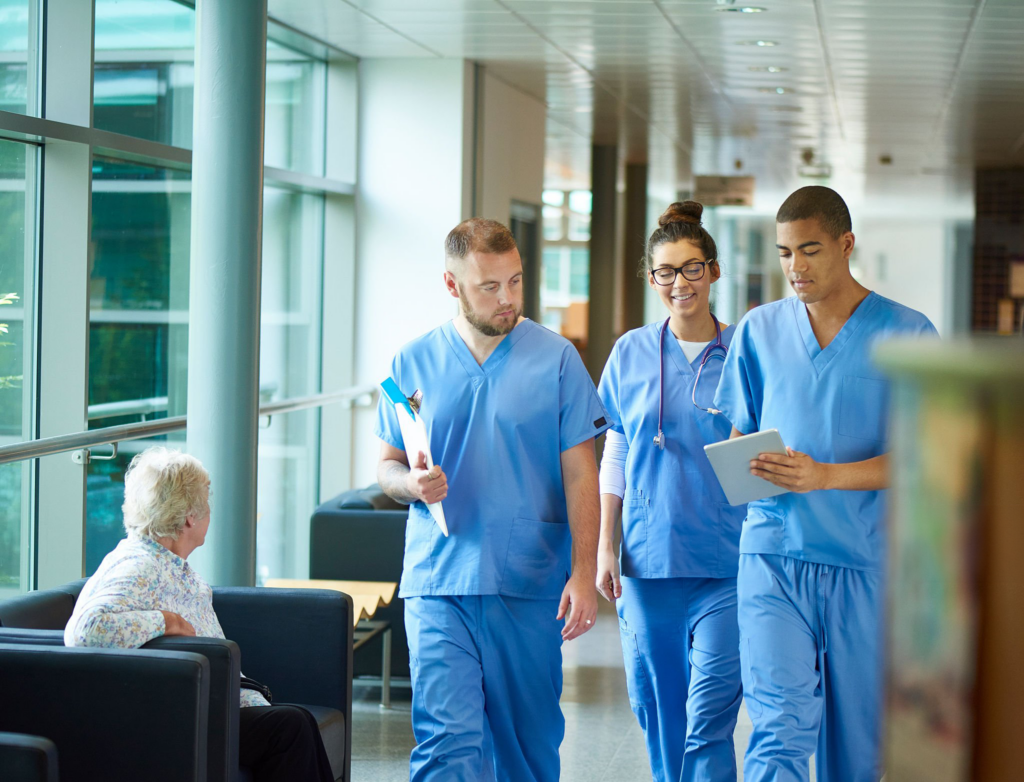 Healthcare professionals walking in hospital corridor.