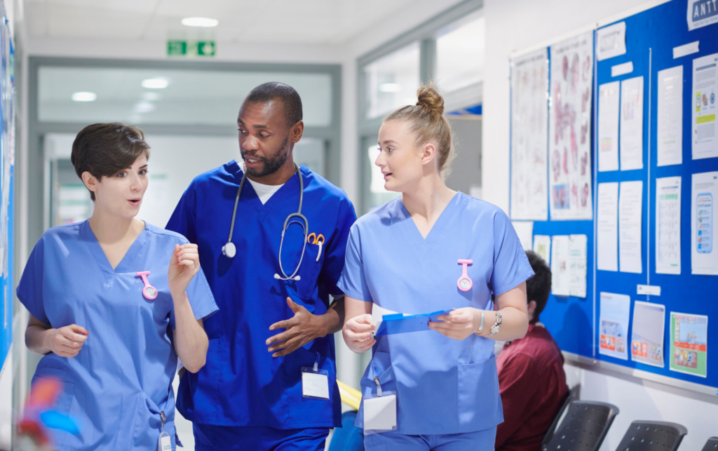 Healthcare professionals walking in hospital corridor.