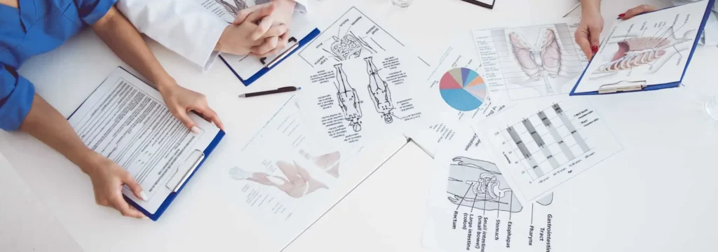 Medical notes and anatomy diagrams on a desk representing preparation for the MSRA exam and Medset’s online MSRA question bank